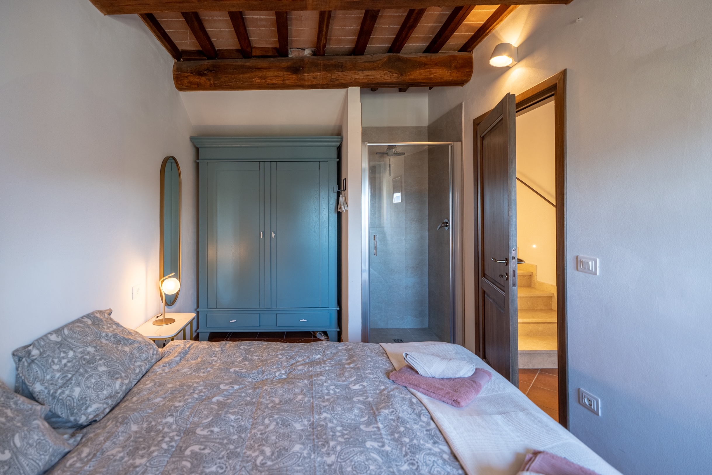 Queen bedroom with exposed beams and en-suite bathroom