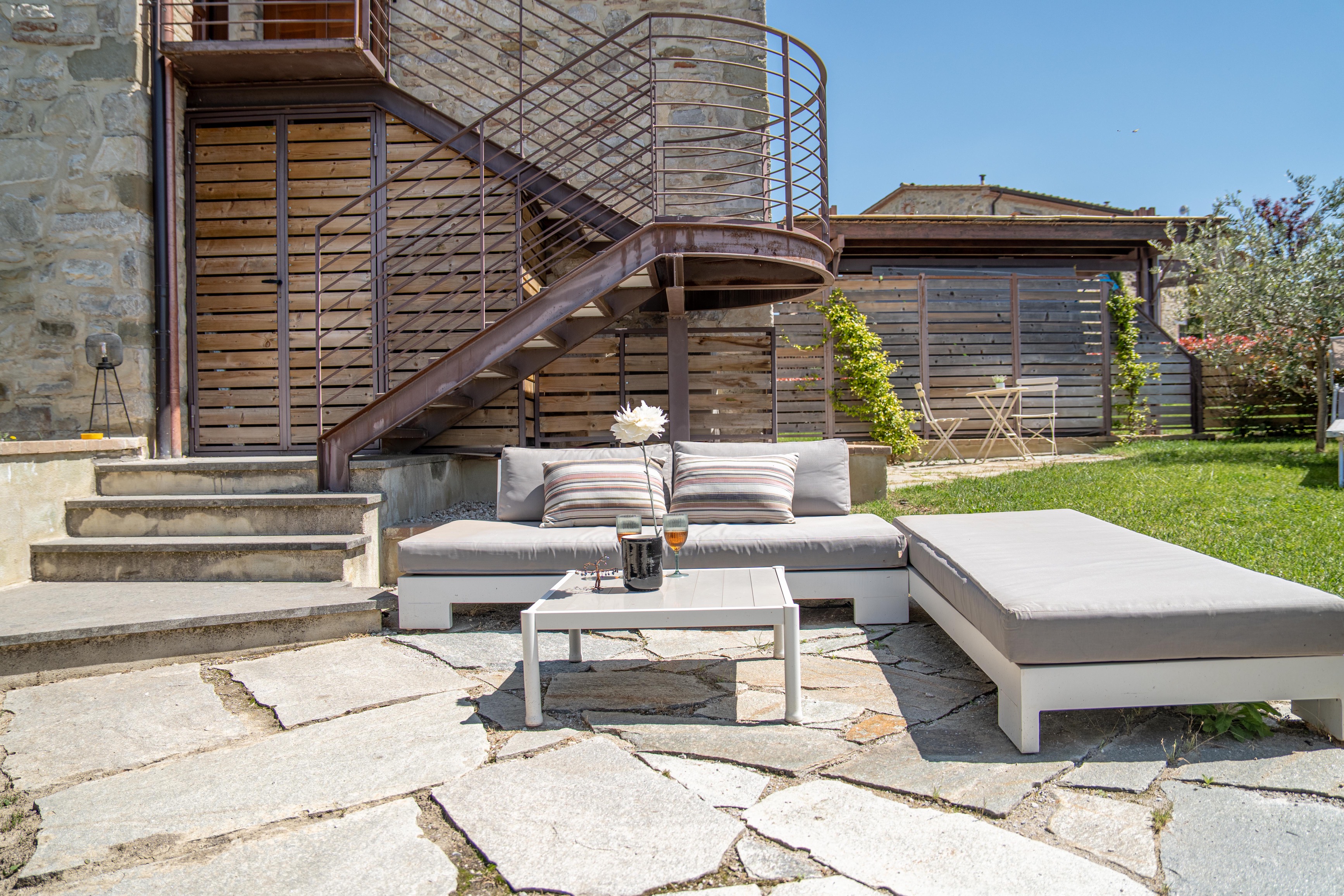 Private terrace lounge with spiral staircase and stone paving